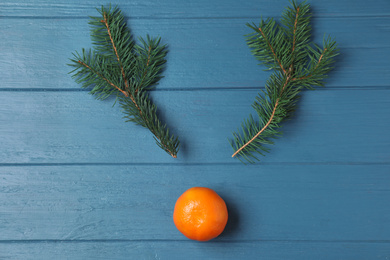 Flat lay composition with tangerine and fir branches on blue wooden table