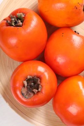 Photo of Delicious ripe persimmons on table, top view