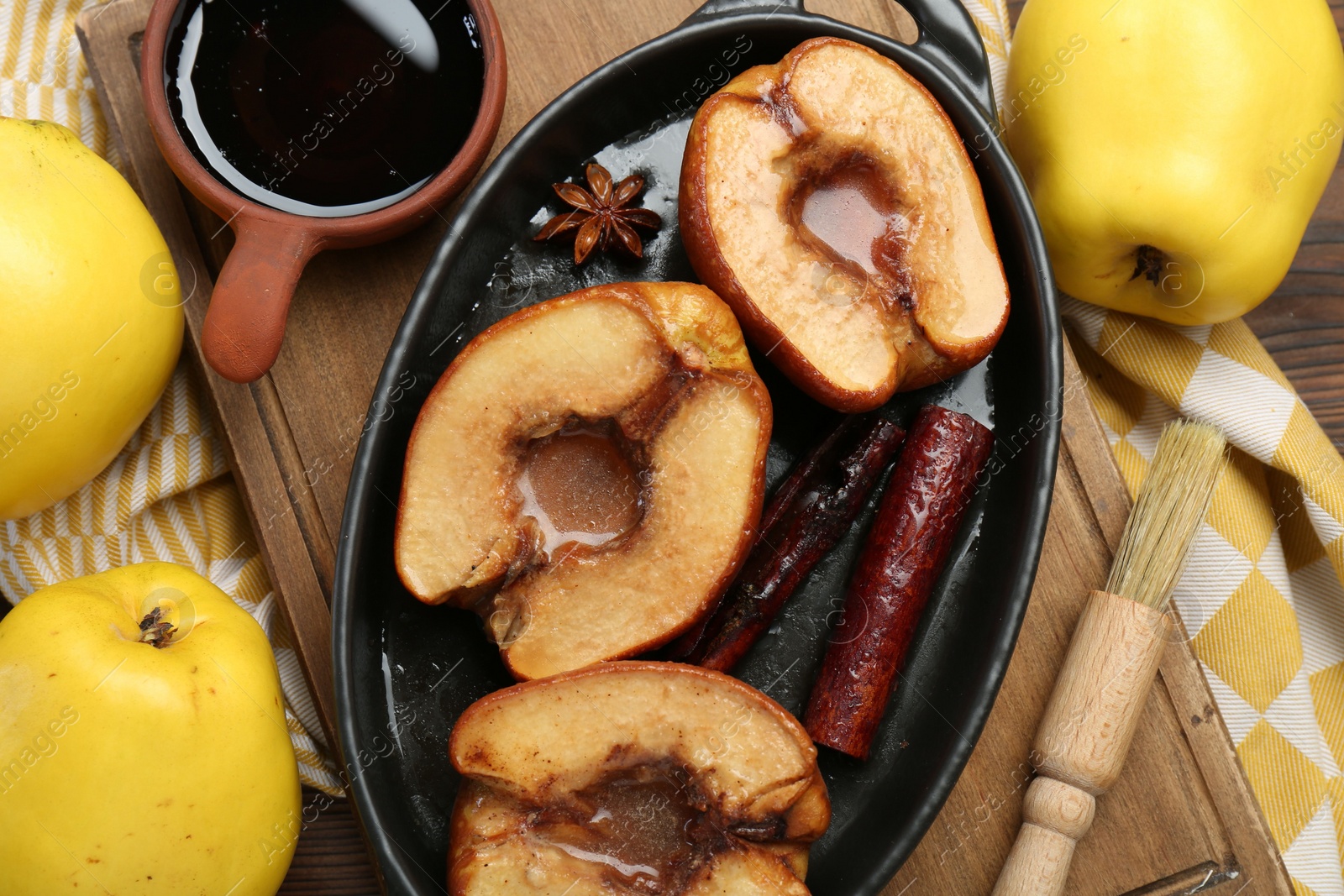 Photo of Tasty baked quinces served with sauce on table, flat lay