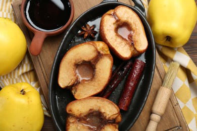 Tasty baked quinces served with sauce on table, flat lay