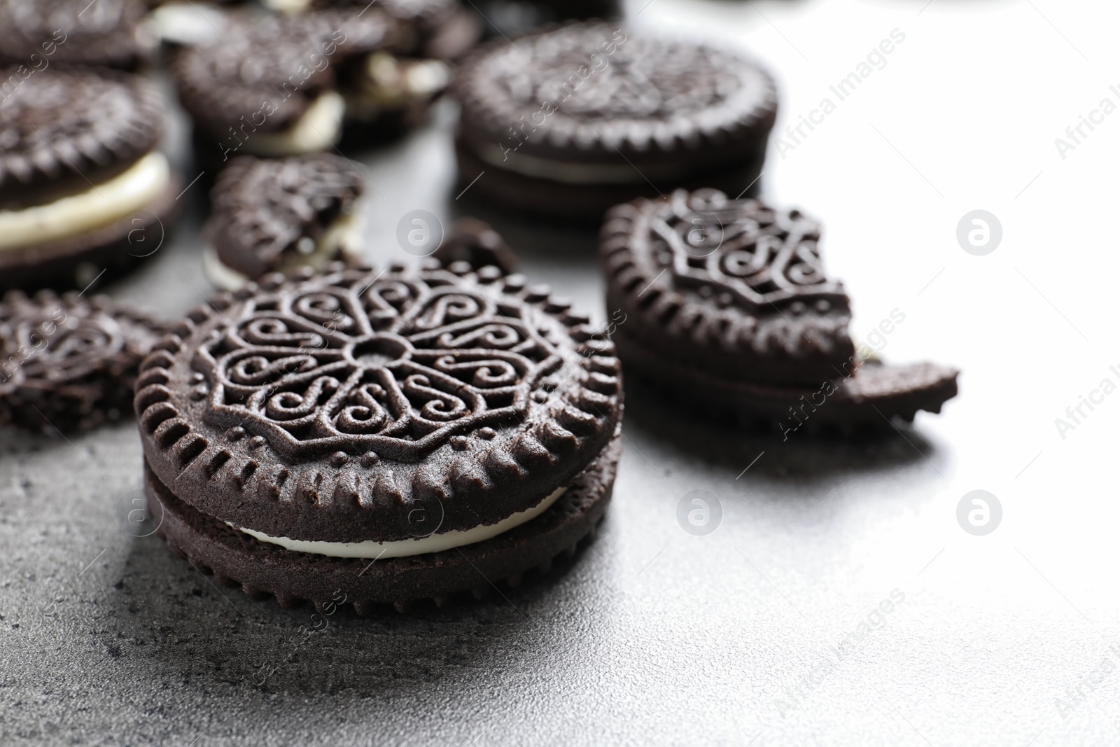 Photo of Tasty chocolate cookies with cream on grey background, closeup. Space for text