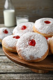 Photo of Pastry stand with delicious jelly donuts on wooden table