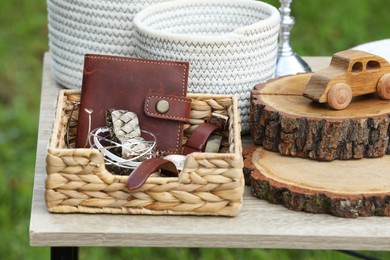 Many different decorative items on wooden table outdoors. Garage sale