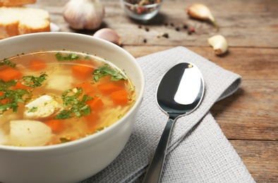 Photo of Bowl with fresh homemade chicken soup on wooden table, space for text