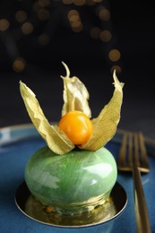 Photo of Delicious mousse cake decorated with physalis fruit on black background, closeup