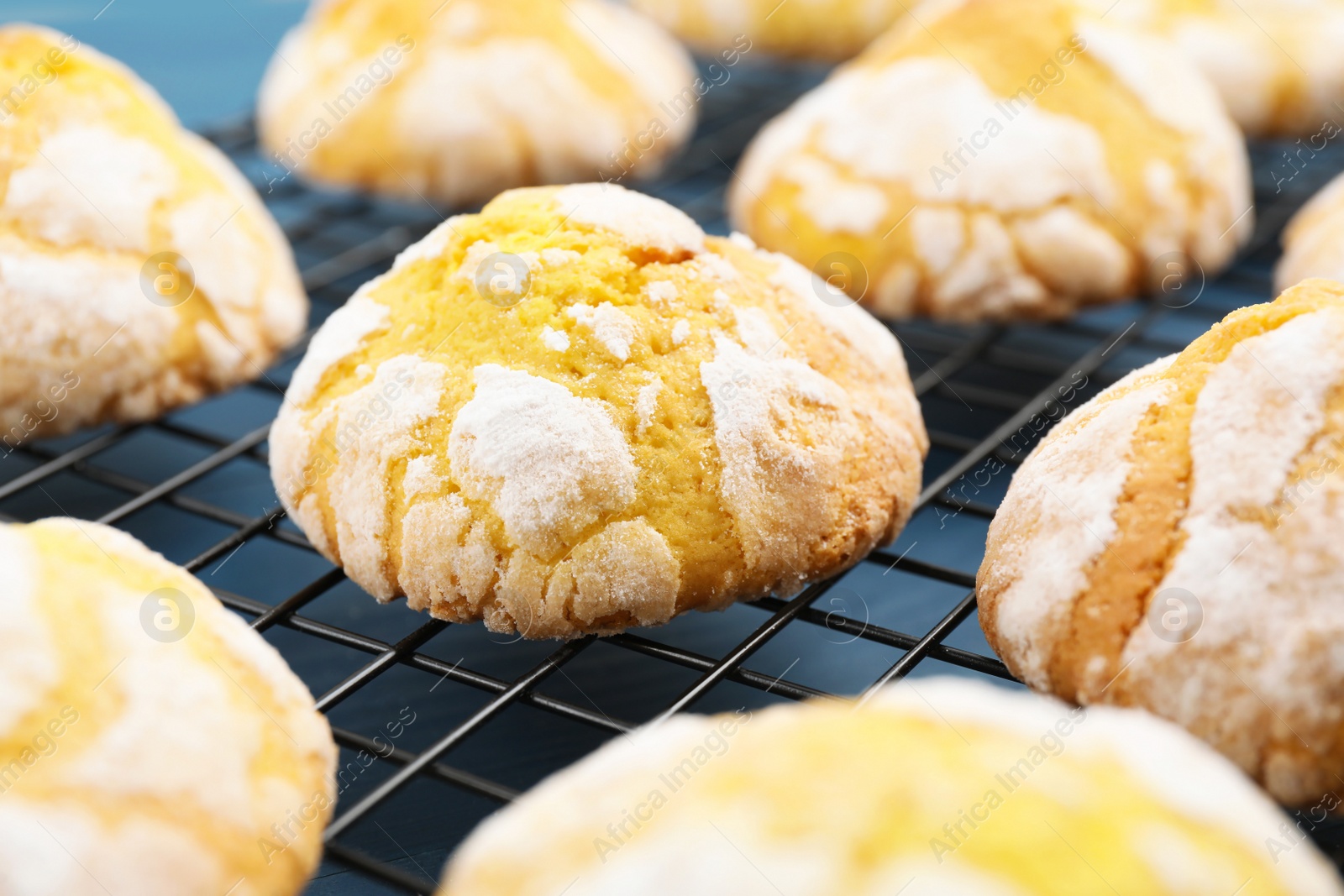 Photo of Tasty homemade lemon cookies on cooling rack, closeup