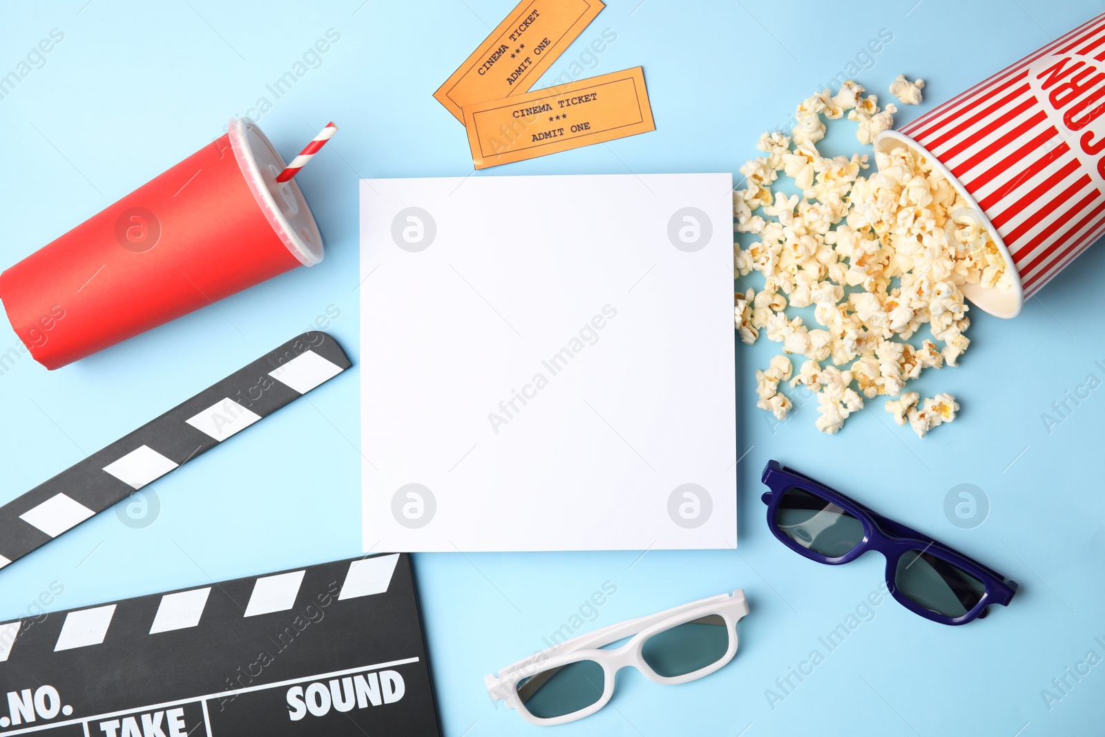 Photo of Flat lay composition with blank paper, popcorn and clapper on color background, mockup for design. Watching cinema