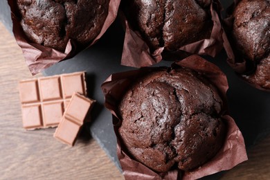 Photo of Tasty chocolate muffins on wooden table, top view
