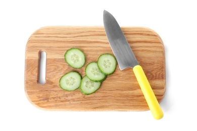 Photo of Wooden cutting board with cucumber slices and chef's knife isolated on white, top view