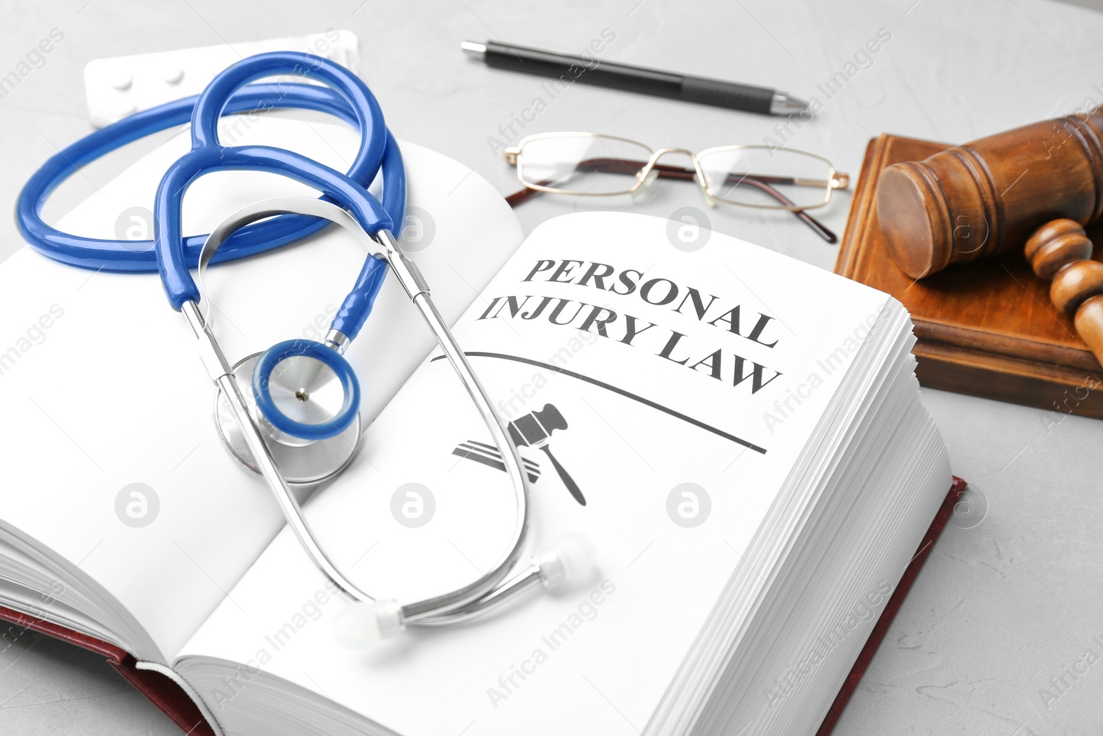 Photo of Book with words PERSONAL INJURY LAW and stethoscope on table