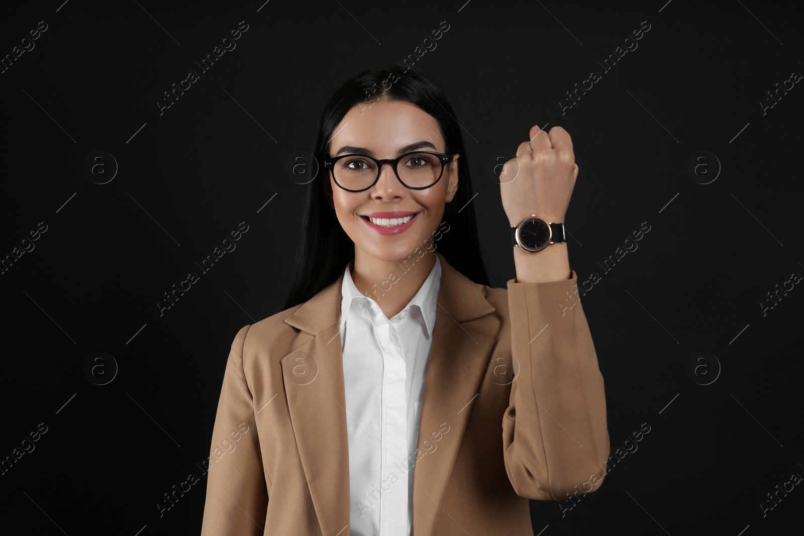 Photo of Businesswoman with wristwatch on black background. Time management