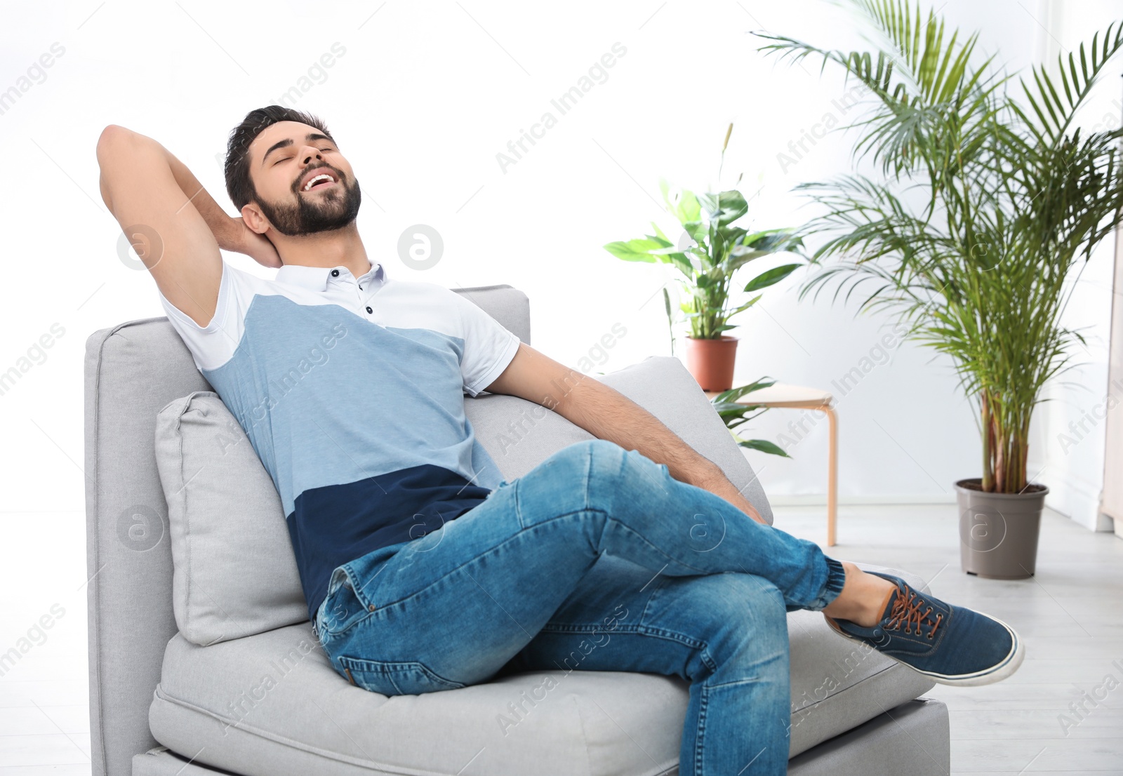 Photo of Young man relaxing on couch at home