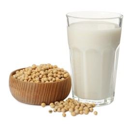 Glass of fresh soy milk and bowl with beans on white background