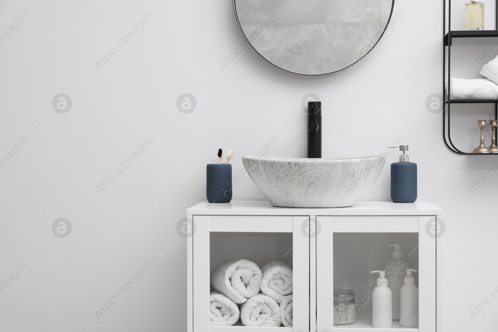 Photo of Different bath accessories and personal care products near sink on bathroom vanity, space for text