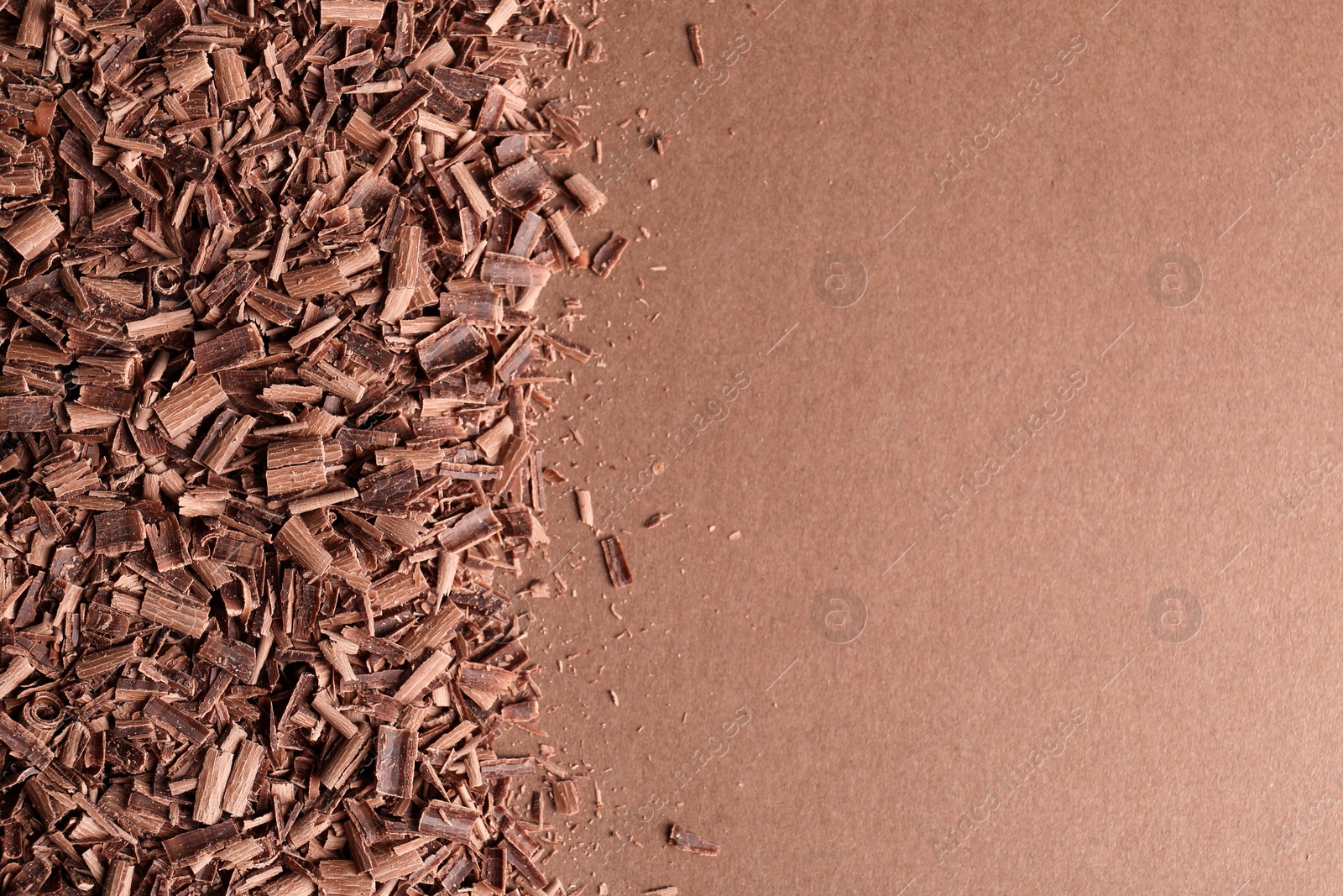 Photo of Chocolate curls and space for text on color background, top view