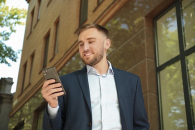 Young man using smartphone on city street