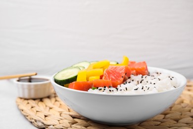 Photo of Delicious poke bowl with salmon, rice and vegetables on white table, closeup