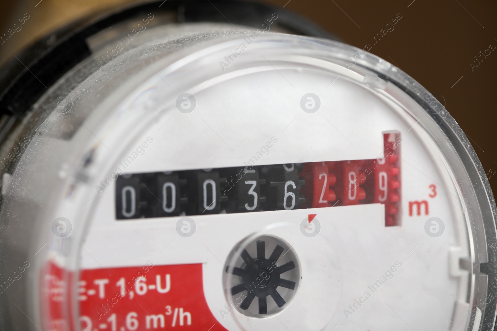 Photo of Electric meter on blurred background, closeup view. Water measuring device