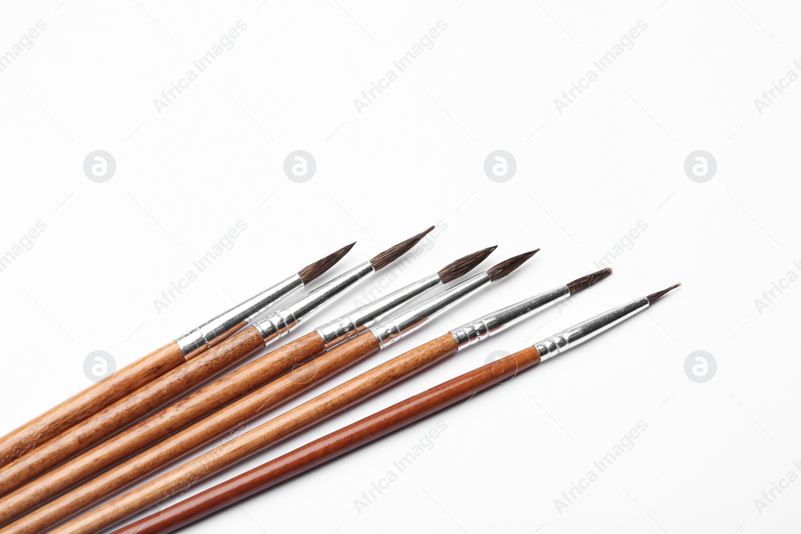 Photo of Different paint brushes on white background, top view