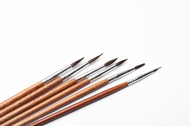 Photo of Different paint brushes on white background, top view