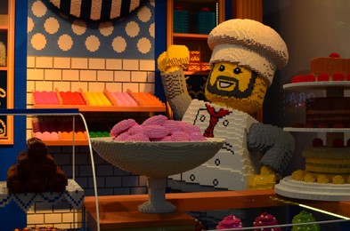 Photo of Paris, France - December 10, 2022: Chef figure and different pastries made of colorful Lego constructor in store display