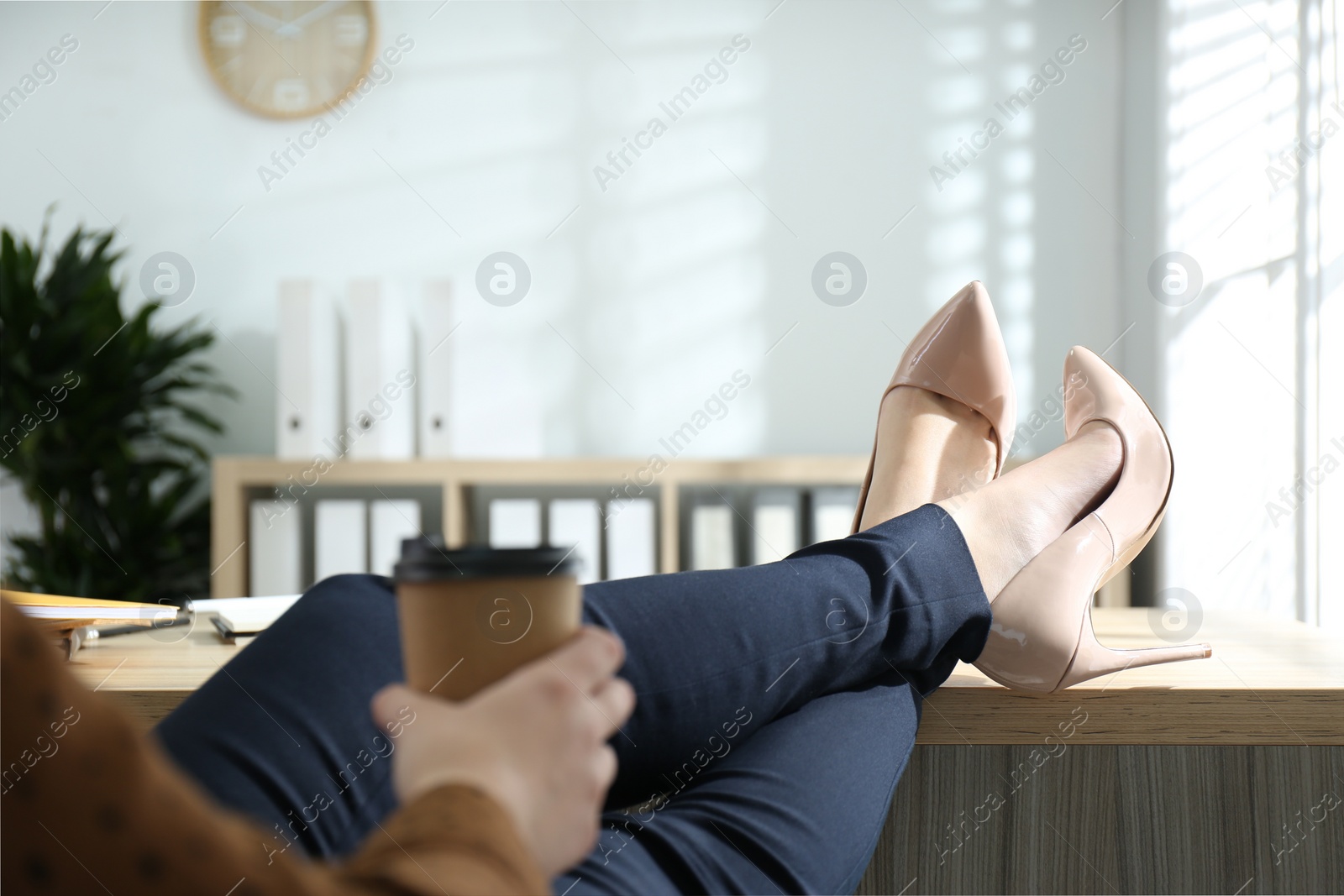 Photo of Lazy worker with feet on desk in office, closeup