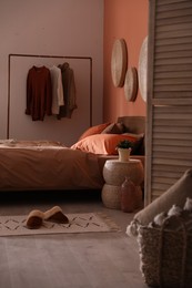 Bed with orange and brown linens in stylish room