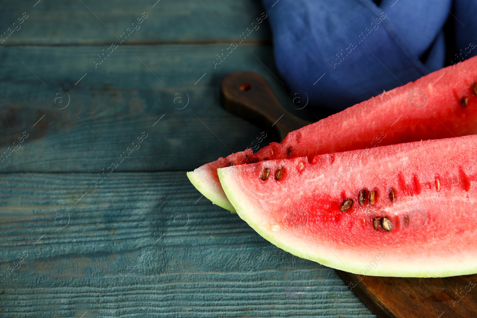 Photo of Yummy watermelon slices on wooden table, closeup. Space for text