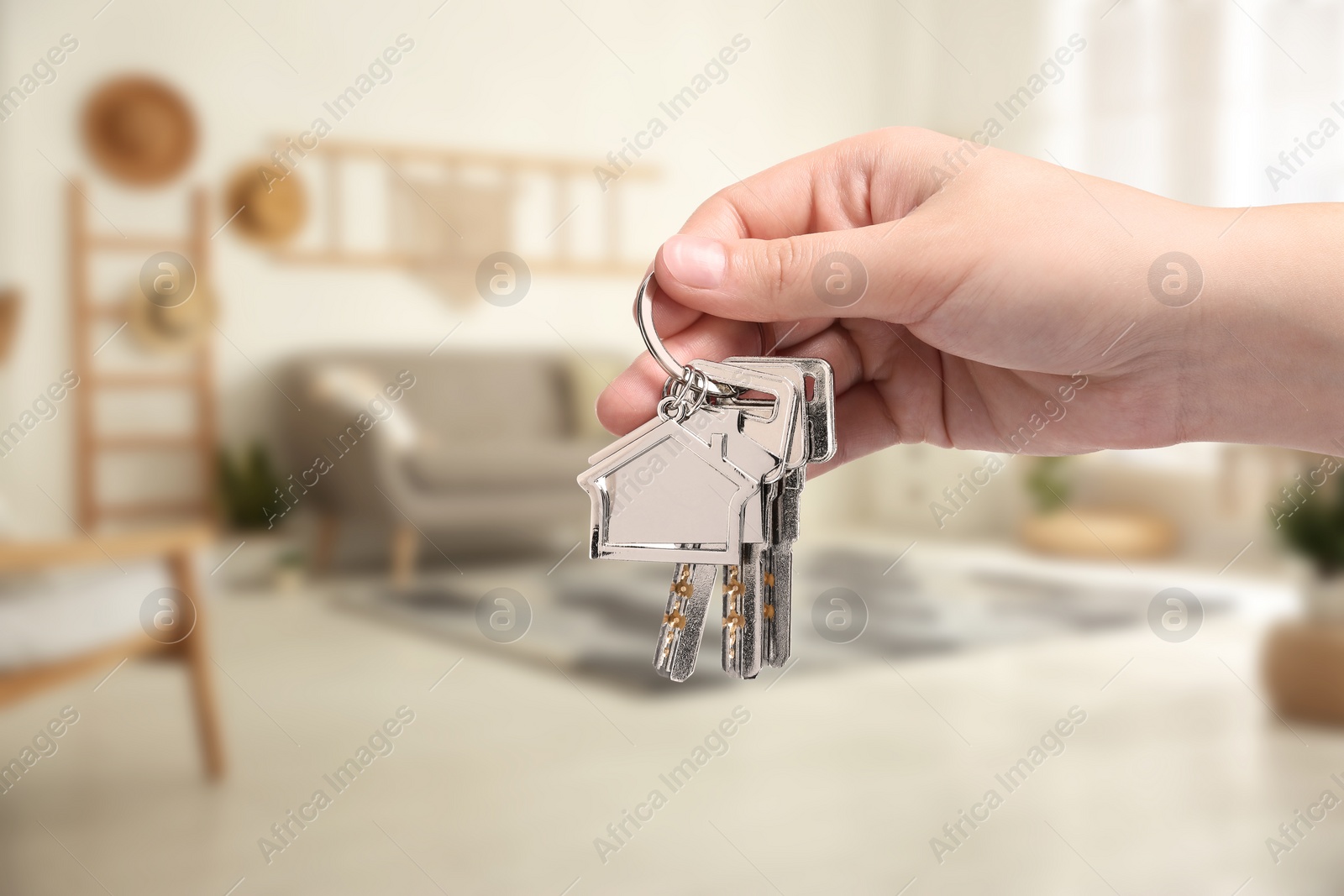 Image of Woman holding house keys in room, closeup