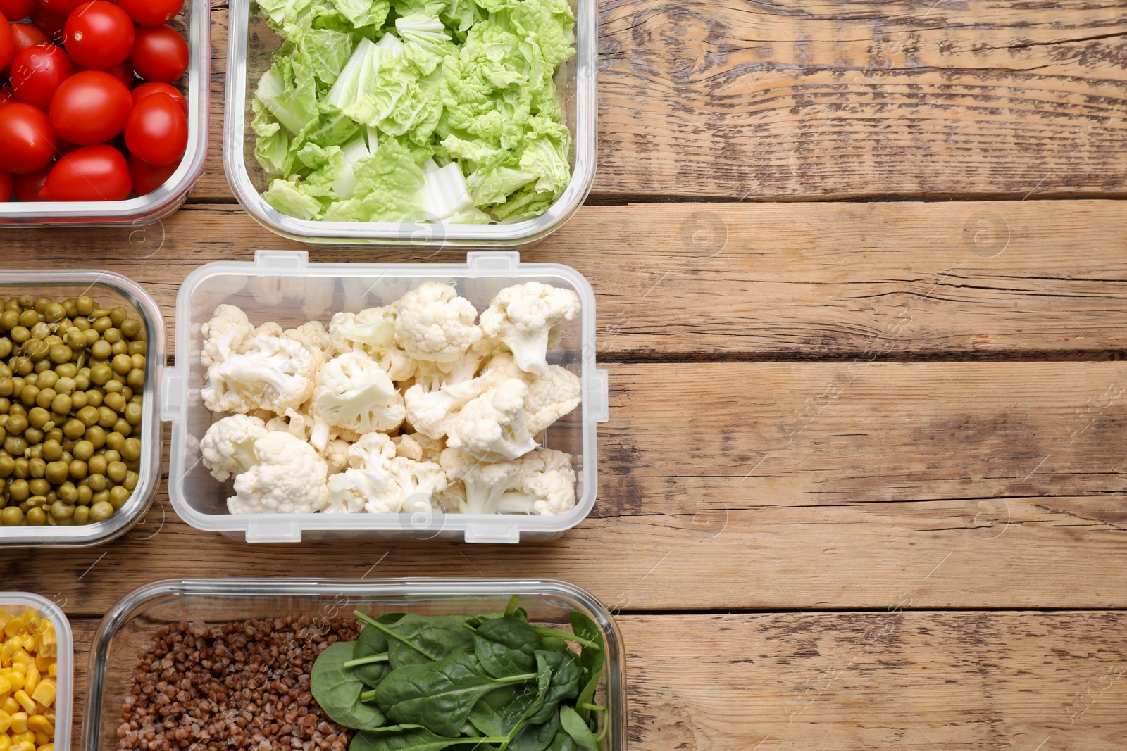 Photo of Plastic and glass containers with different fresh products on wooden table, flat lay. Space for text