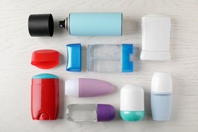 Photo of Flat lay composition with different deodorants on white wooden table