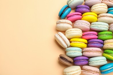 Delicious colorful macarons on beige background, flat lay. Space for text