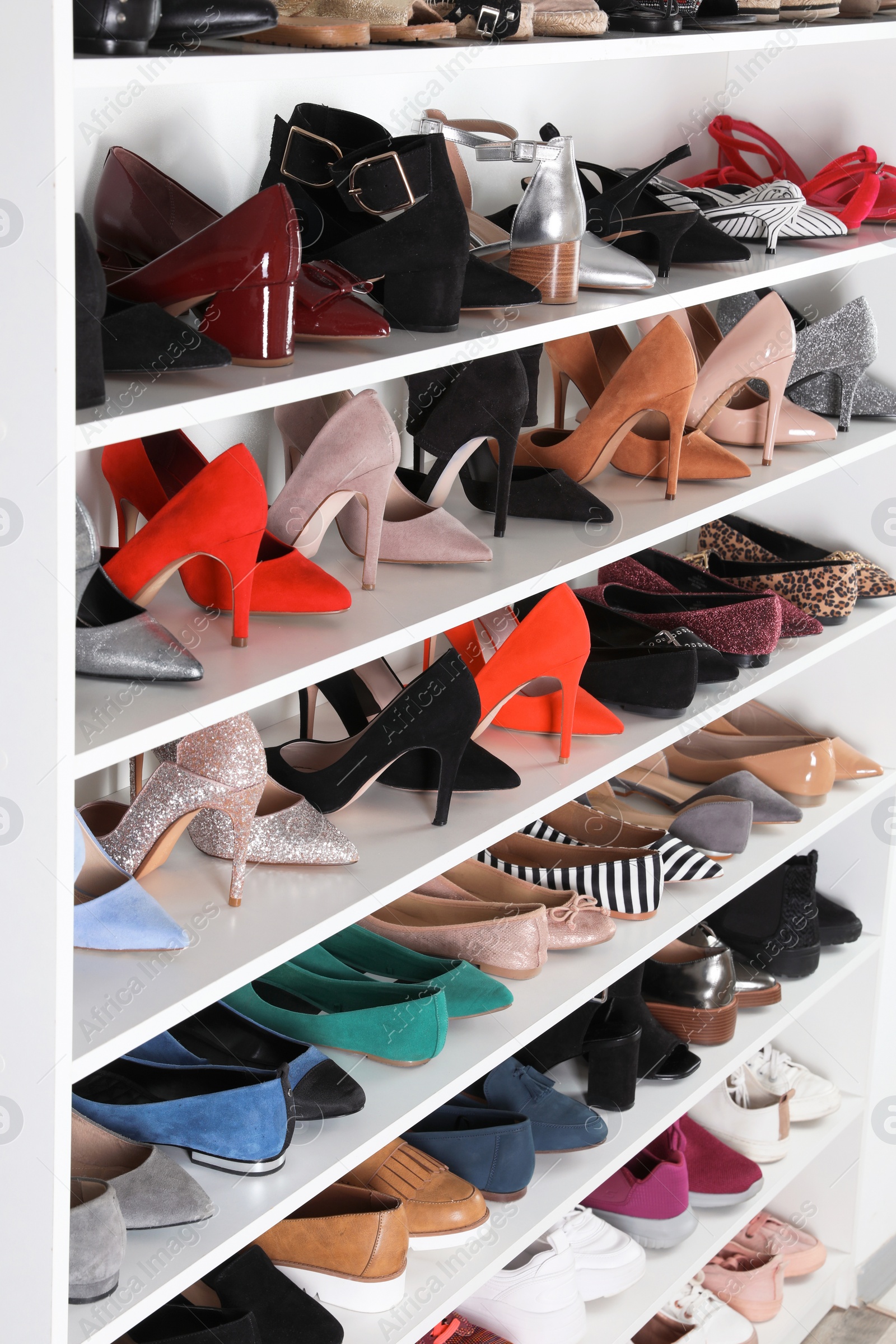 Photo of Shelving unit with different shoes. Element of dressing room interior