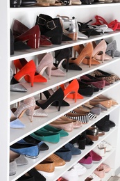 Shelving unit with different shoes. Element of dressing room interior