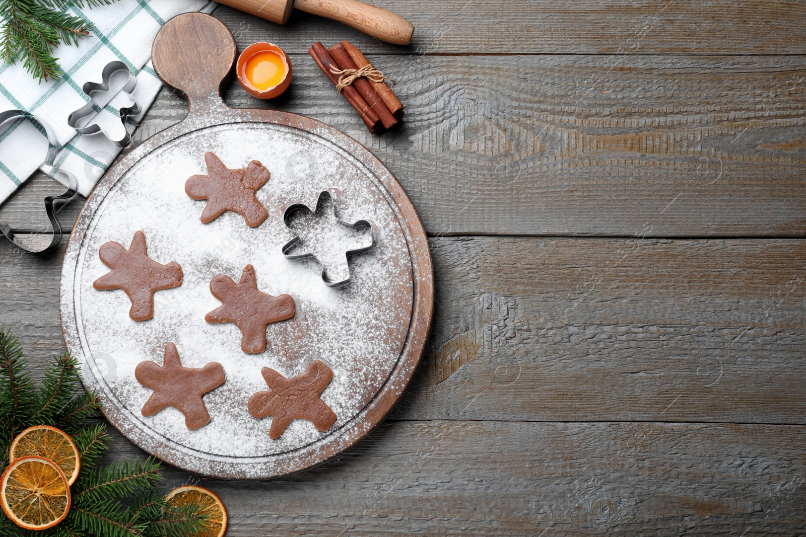 Photo of Flat lay composition with homemade gingerbread man cookies on wooden table, space for text