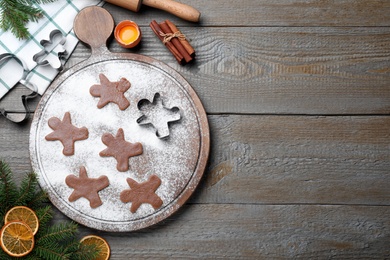Photo of Flat lay composition with homemade gingerbread man cookies on wooden table, space for text