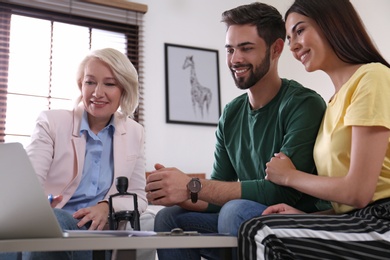 Female notary working with young couple in office