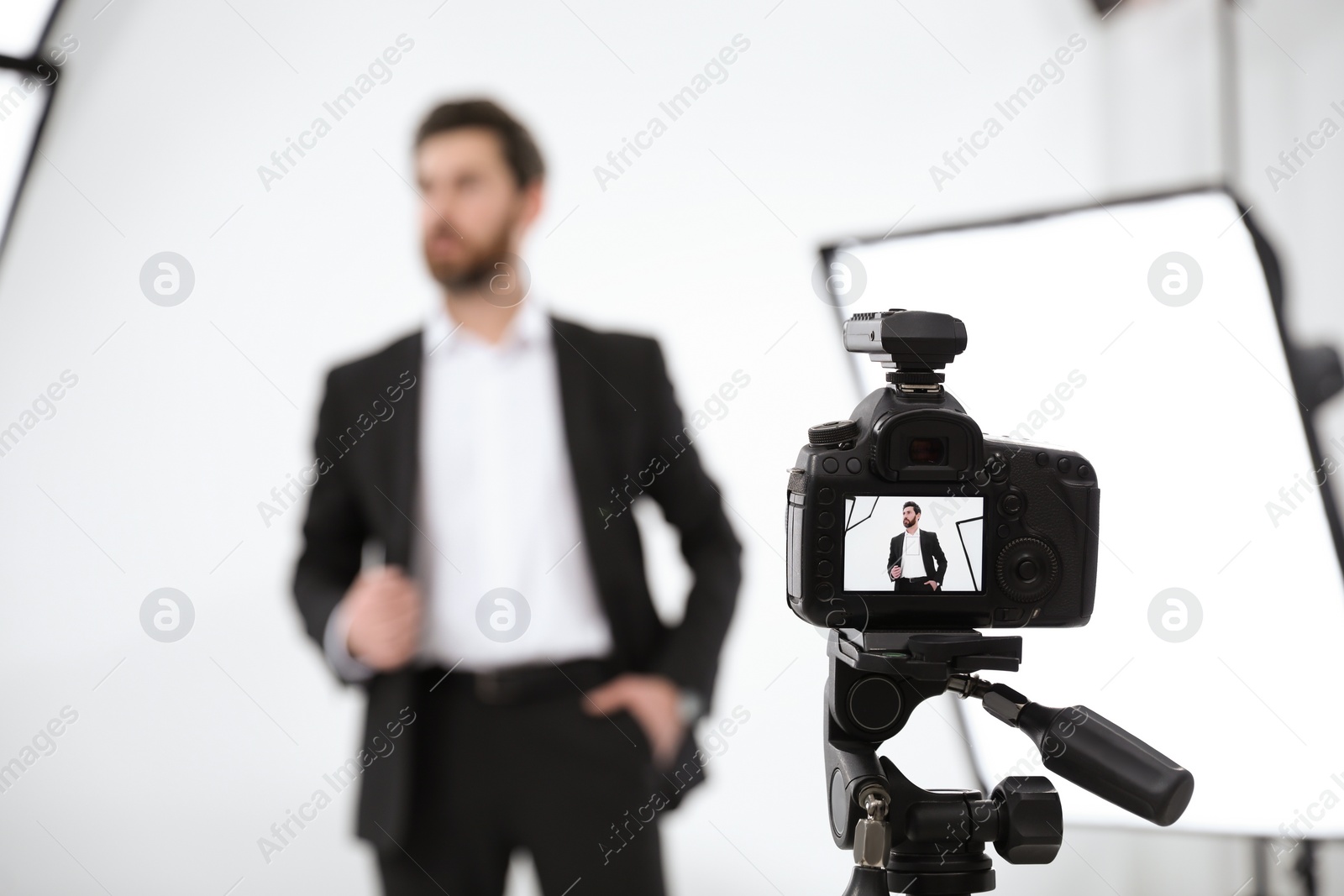 Photo of Handsome model posing for camera in modern studio, selective focus. Professional photo session