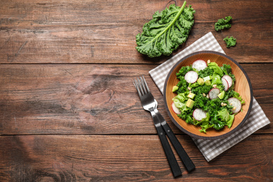 Photo of Delicious kale salad on wooden table, flat lay. Space for text