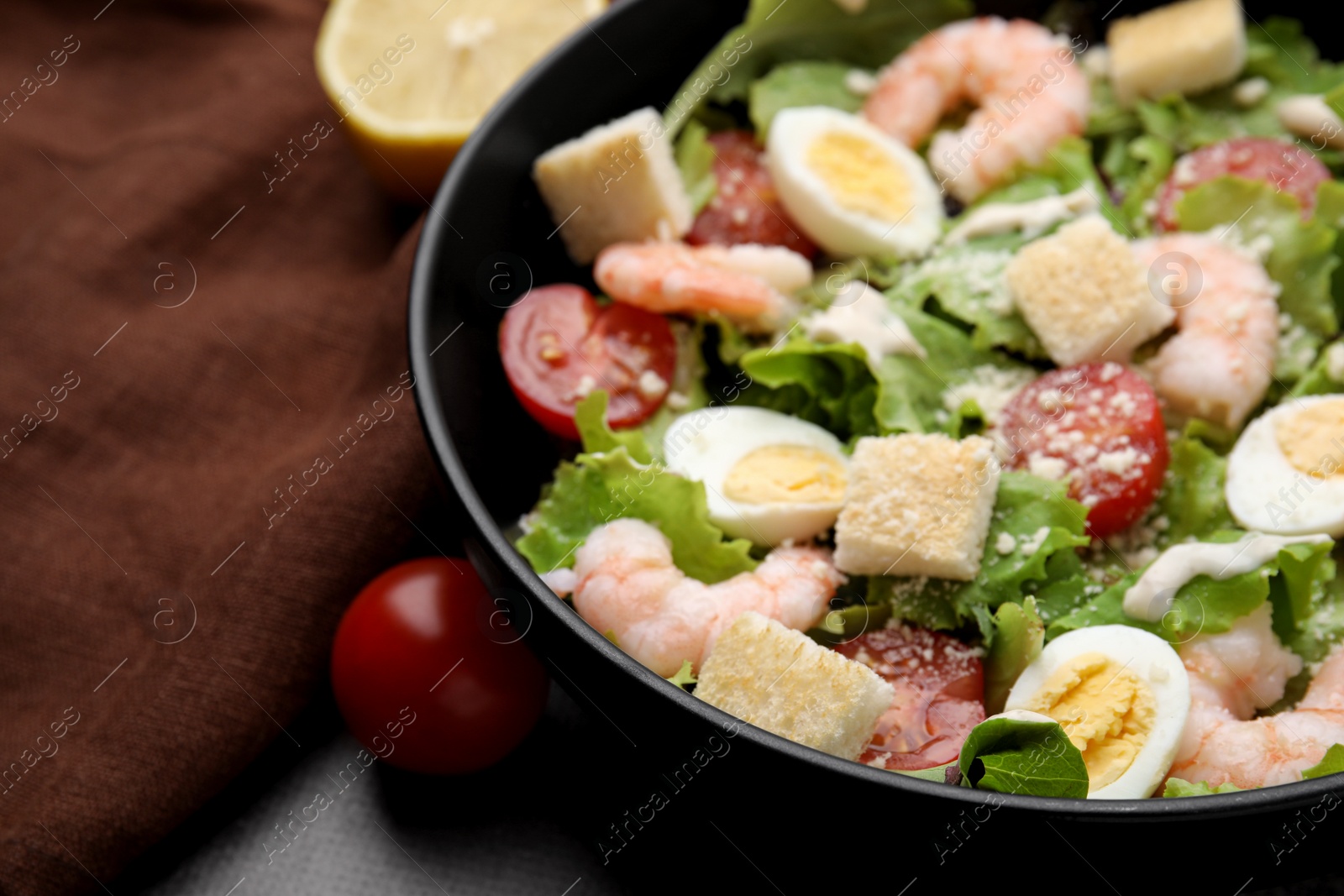 Photo of Delicious Caesar salad with shrimps on table, closeup