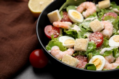 Delicious Caesar salad with shrimps on table, closeup