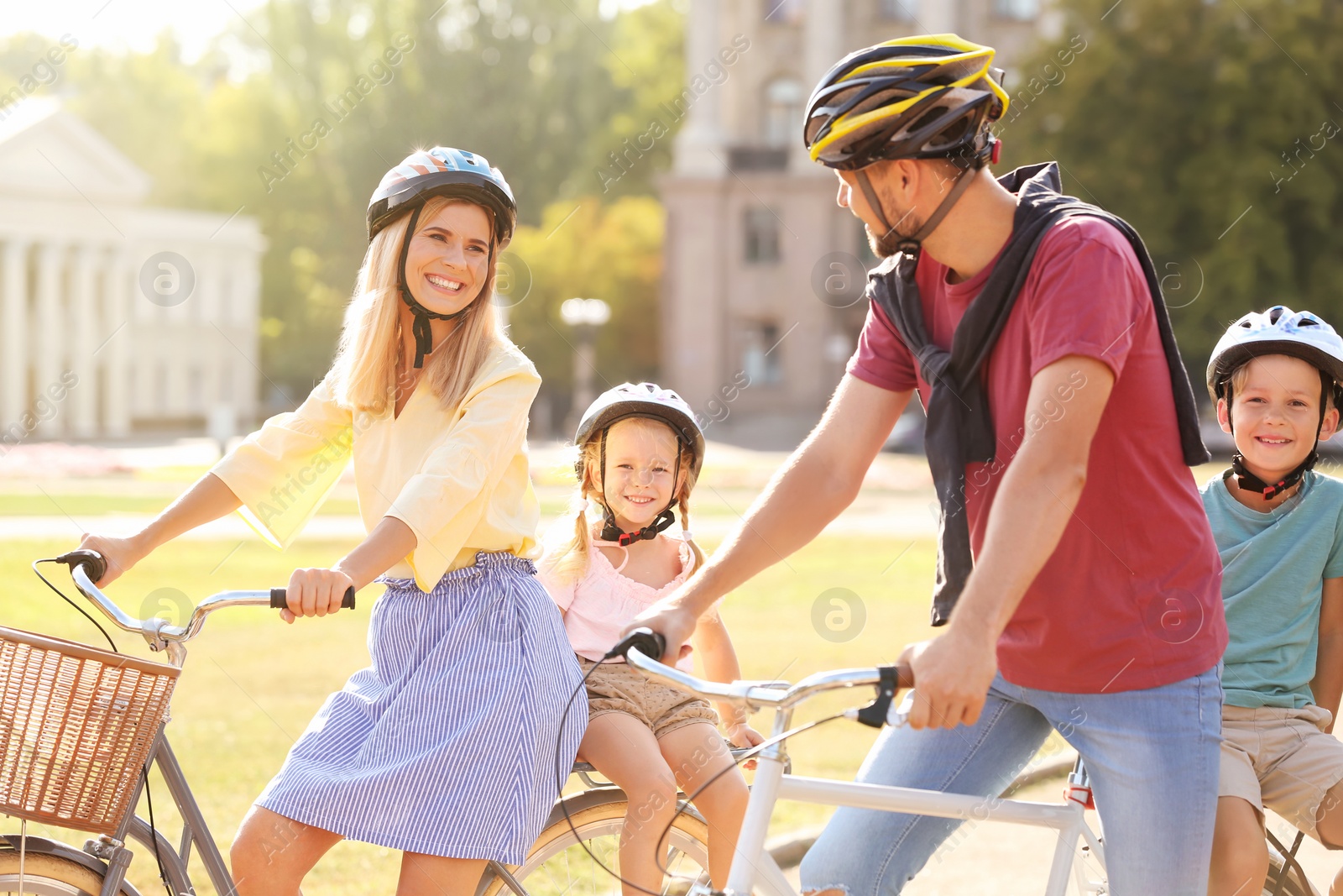 Photo of Happy family riding bicycles outdoors on summer day