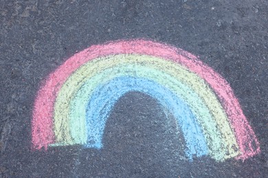 Child's chalk drawing of rainbow on asphalt, above view