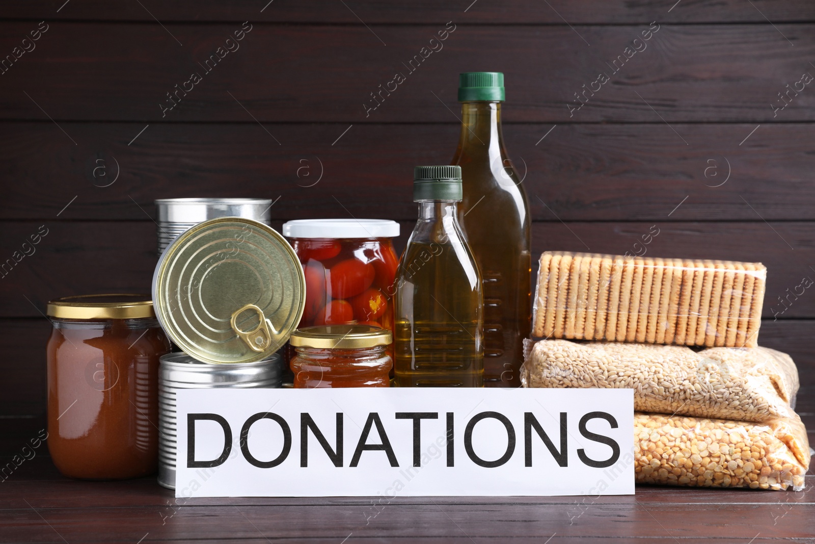 Photo of Card with word Donations and different products on wooden table