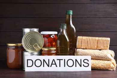 Card with word Donations and different products on wooden table