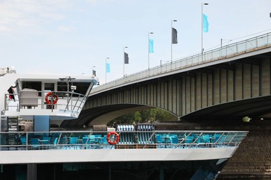 Modern ferry ship near bridge on sunny day