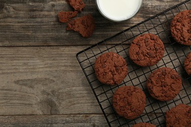 Delicious chocolate chip cookies and milk on wooden table, flat lay. Space for text