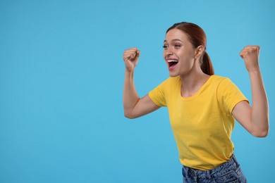 Photo of Happy fan celebrating on light blue background, space for text
