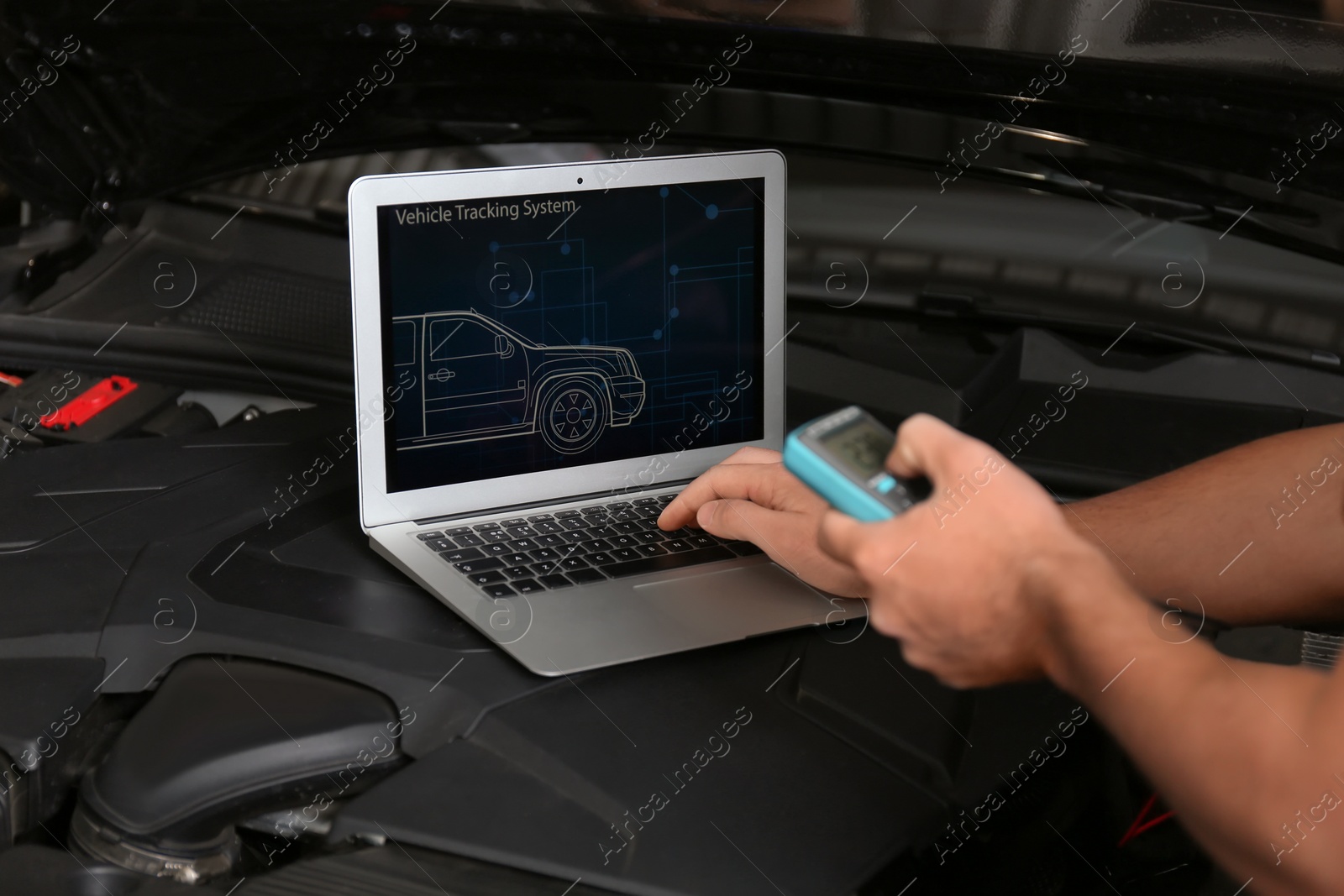 Photo of Mechanic with laptop doing car diagnostic at automobile repair shop, closeup