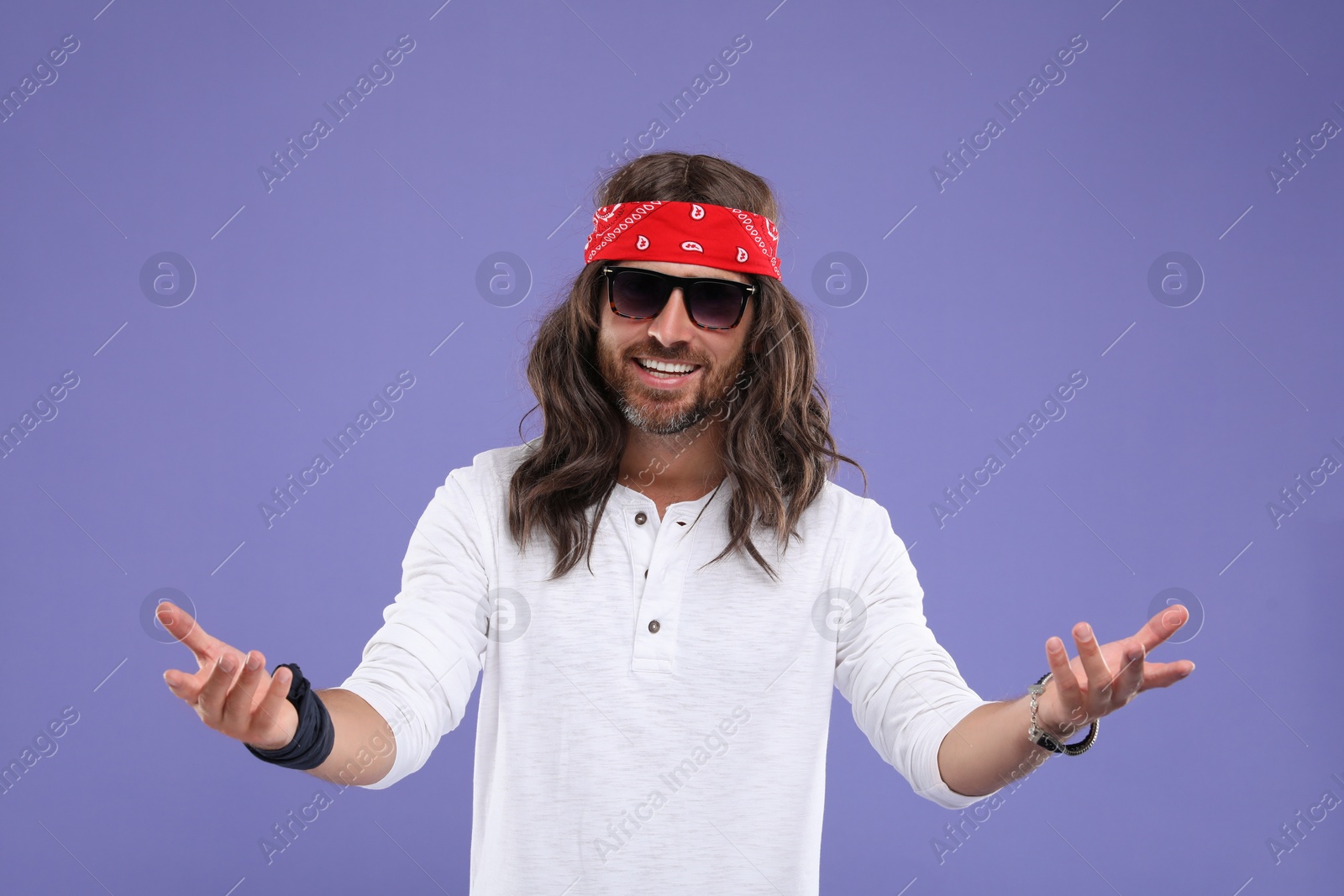 Photo of Stylish hippie man in sunglasses on violet background